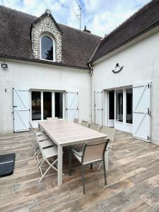una casa bianca con un tavolo e sedie su un patio di Ô Refuge de Théo et Vic' a Saint-Martin-du-Vieux-Bellême Altre 6 foto