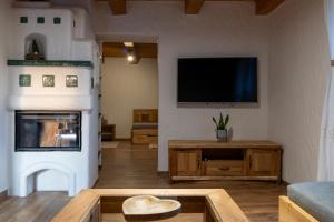 a living room with a television and a fireplace at Byt pri jazere in Spišský Štiavnik