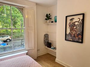 a bedroom with a bed and a window with a view at Private and Cosy 1 Bed Flat By Burges Park in London