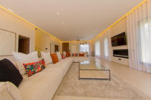a living room with a couch and a glass coffee table at Beautiful new villa with private pool in El Rhechat