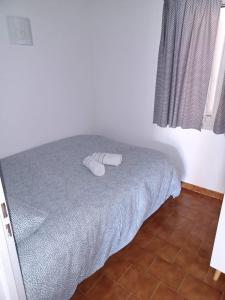 een slaapkamer met een bed met twee witte slippers erop bij Nice apartment with pool - near the beach in Bandol