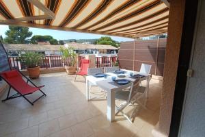 een patio met een witte tafel en rode stoelen bij Nice apartment with pool - near the beach in Bandol +23 foto's