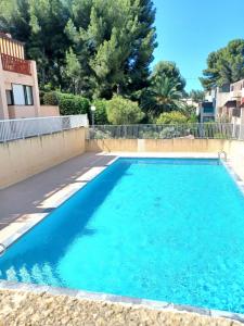 een zwembad met blauw water in een tuin bij Nice apartment with pool - near the beach in Bandol