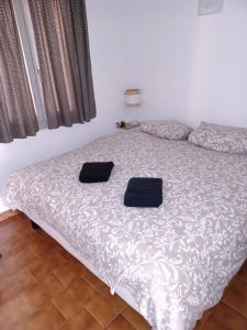 een bed met twee zwarte kussens erop bij Nice apartment with pool - near the beach in Bandol