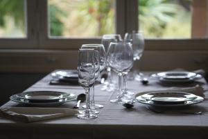 a table with wine glasses and plates on it at Colonial Farmhouse with Cottage - Lugar Minas da Caveira in Grândola