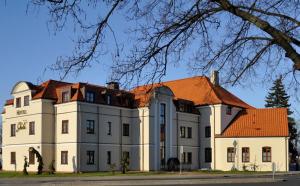 a large white building with an orange roof at Hotel Skala in Biała Podlaska