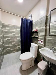 a bathroom with a toilet and a sink at Gensan Homey Apartment in General Santos