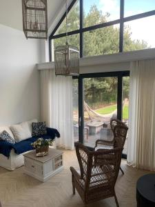 a living room with a couch and chairs in front of a window at NAD JEZIORAMI Niedźwiady in Kolonia Pawłówek