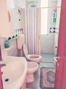 a bathroom with a pink toilet and a sink at Casa Vacanze in Lido Adriano