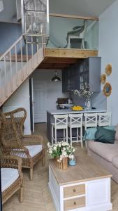 a living room with a staircase and a kitchen at NAD JEZIORAMI Niedźwiady in Kolonia Pawłówek