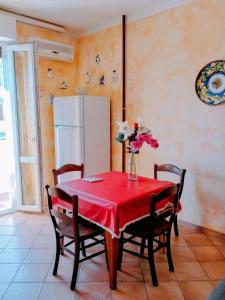 a kitchen with a red table with chairs and a refrigerator at Casa Vacanze in Lido Adriano