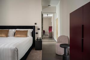 a bedroom with a bed and a chair and a room at Casa Guttmann in Rome