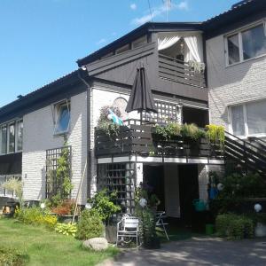 a house with a balcony with an umbrella at Studiolägenhet i villa in Huddinge
