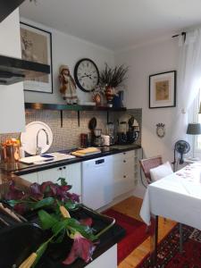 a kitchen with a sink and a clock on the wall at Studiolägenhet i villa in Huddinge