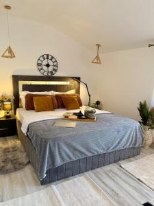 a bedroom with a large bed with a clock on the wall at Botanic Villa Family- cozy&elegant - 4 rooms - 3 bedrooms - factura&vocheredevacanta - 8 oaspeti in Iaşi
