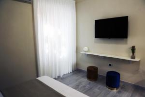 a bedroom with a bed and a flat screen tv at Zibakhome in Monte di Procida
