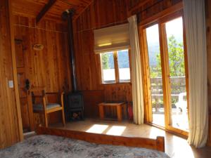 a room with a bed and a window and a stove at Vista Hermosa Conguillio in Conguillío