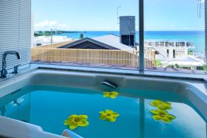 a swimming pool with yellow flowers in it at onna resort nakadomari ビーチまで車で4分 最大8名OK 中庭付き貸切ヴィラでくつろぐ恩納村ステイ in Onna