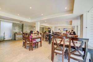 a group of people sitting at tables in a restaurant at FabHotel Prime The King's Court - Nr Calangute Beach in Calangute