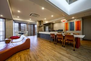 a bedroom with a bed and a dining room and a kitchen at onna resort nakadomari ビーチまで車で4分 最大8名OK 中庭付き貸切ヴィラでくつろぐ恩納村ステイ in Onna +95 photos