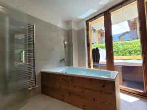 a bathroom with a bath tub and a window at ALPIN 7 Jasná - Free Jacuzzi & Sauna in Demanovska Dolina +38 photos