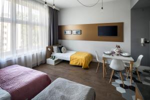 ein Hotelzimmer mit zwei Betten und einem Tisch und einem Schreibtisch in der Unterkunft The Wavelo Collection in Krakau