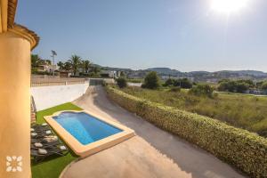 a swimming pool on the side of a house at Villa Benlluire by Abahana Villas in Moraira