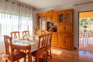 a dining room with a table and wooden cabinets at Villa Benlluire by Abahana Villas in Moraira