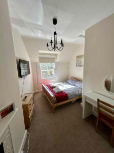 a bedroom with a bed and a chandelier at 4 bedroom townhouse Kirkcudbright in Kirkcudbright
