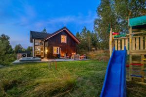 Cabaña de madera con tobogán y parque infantil en Villa Heidi, en Ulven