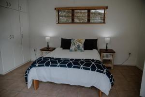 a bedroom with a large bed and two night stands at Sea La Vie- beach cottage in Port Edward