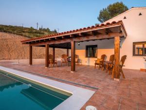 a patio with a table and chairs next to a swimming pool at Casa Clarita hasta 21 personas, piscina a 40 min de Madrid y aeropuerto in Perales de Tajuña
