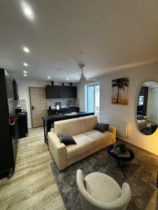 a living room with a couch and a kitchen at Appartement cosy face au château de Lourdes in Lourdes