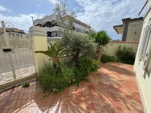 un cortile con piante e una recinzione con un edificio di Villa Ginevra ad Anzio Altre 9 foto