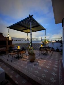 a patio with tables and chairs on a roof at Riad Azula in Salé +49 photos
