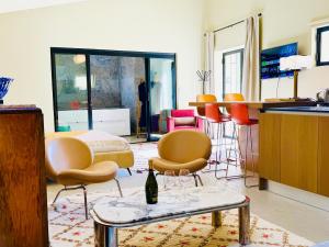 a room with chairs and a table with a bottle of wine at Proche l'Isle/Sorgue, loft avec SPA et Piscine in Le Thor +29 photos