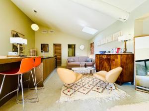 a living room with orange chairs and a couch at Proche l'Isle/Sorgue, loft avec SPA et Piscine in Le Thor