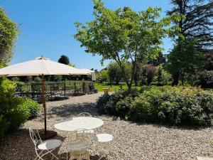 a picnic table with an umbrella in a park at Proche l'Isle/Sorgue, loft avec SPA et Piscine in Le Thor