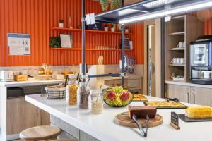 een keuken met een aanrecht met eten erop bij ibis budget Toulouse Labège in Labège
