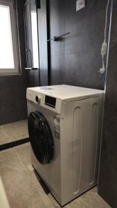 a white washing machine in a bathroom with a window at Hermanos Apartments 702 in Shëngjin
