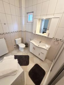 a white bathroom with a sink and a toilet at Garden House Heybeliada in Adalar +15 photos