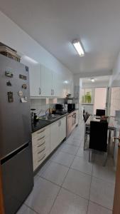 a kitchen with a refrigerator and a table in it at Casa Nobrega in Caniço