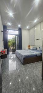 a bedroom with a bed and a large window at COMIC Homestay in Da Nang