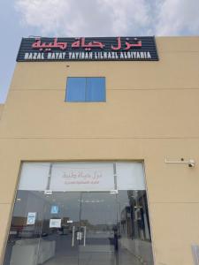 a building with a sign on the side of it at نزل حياة طيبة للنزل السياحة in Al Nawārīyah