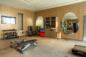 a gym with two treadmills and a mirror at Merlis Hotel Coimbatore in Coimbatore