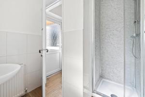 a white bathroom with a shower and a sink at NEW! Spacious 4 bedroom 4BR with Private Parking near city Centre in Leamington Spa