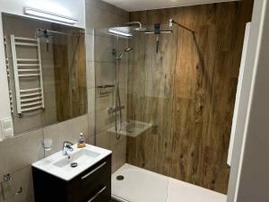 a bathroom with a shower and a sink and a shower at Apartament Wygodny 2 in Białystok +5 photos