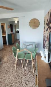 a living room with two chairs and a clock on the wall at Horizonte al Mar in Miramar +22 photos