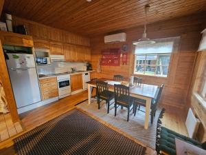 a kitchen with a table and chairs and a refrigerator at Pyhä Aava in Pyhätunturi