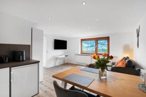a kitchen and a living room with a table at Fewo Weitblick - Haus Sommerberg in Baiersbronn